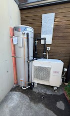 Hot water cylinder and heat pump unit installed outside a Christchurch home