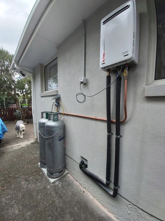 Rinnai Infinity gas hot water unit and twin LPG gas bottles installed outside a Christchurch home